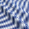 View 4 of product The Turnbull & Asser Navy & White Stripe Cotton Modern Pyjama Set features blue and white Bengal stripes with red piping, a long-sleeve button-up top, chest pocket, and matching pants. Shown laid flat on a white background.