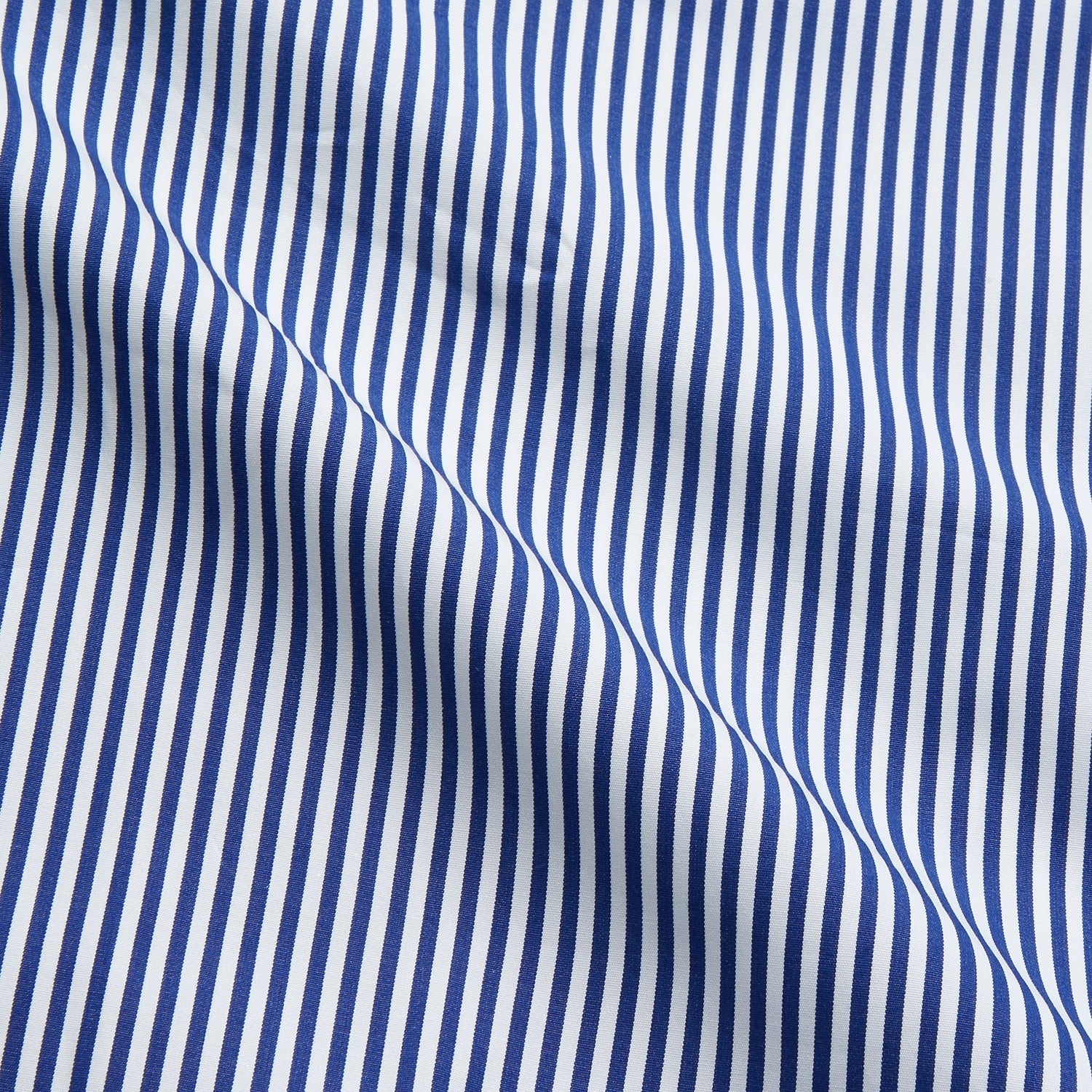 View 4 of product The Turnbull & Asser Navy & White Stripe Cotton Modern Pyjama Set features blue and white Bengal stripes with red piping, a long-sleeve button-up top, chest pocket, and matching pants. Shown laid flat on a white background.