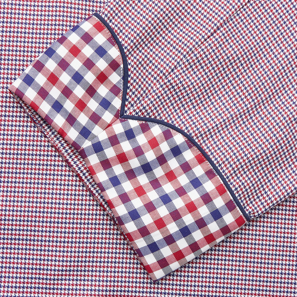 The Turnbull & Asser Burgundy Multi Check Contrast Cotton Gown features a long silhouette with a shawl collar, waist tie, and three pockets, accented by red, black, and white checkered trim—ideal for luxurious nights at home.
