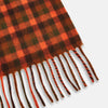 View 3 of product A man stands against a beige background wearing a navy long-sleeve shirt, brown pants, and a Turnbull & Asser Orange Multi Shepherd Check Cashmere Scarf draped around his neck. He faces forward with a neutral expression.