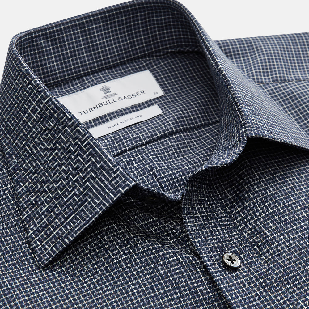 A man in a tie wears the Turnbull & Asser Navy Check Regular Fit Flannel Shirt with T&A collar and 3 button cuffs.