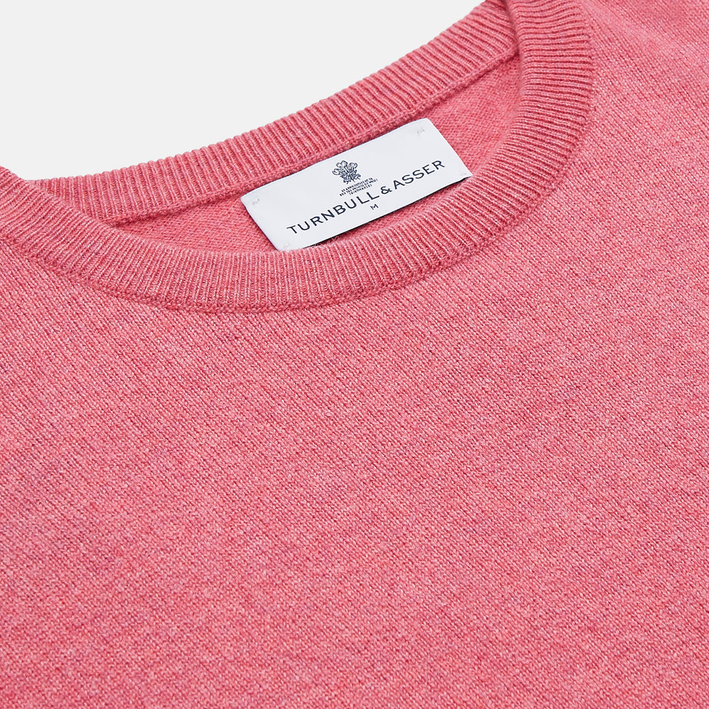 The Turnbull & Asser Pink Cashmere Glenn Jumper is a solid pink, long-sleeved menswear sweater with a crewneck, shown laid flat on a white background.