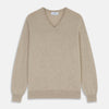 View 1 of product The Turnbull & Asser Beige Cashmere Paden V-Neck Jumper is laid flat on a white background. Knitted in Scotland, this men's staple features ribbed cuffs, hem, and neckline with a soft, smooth texture.