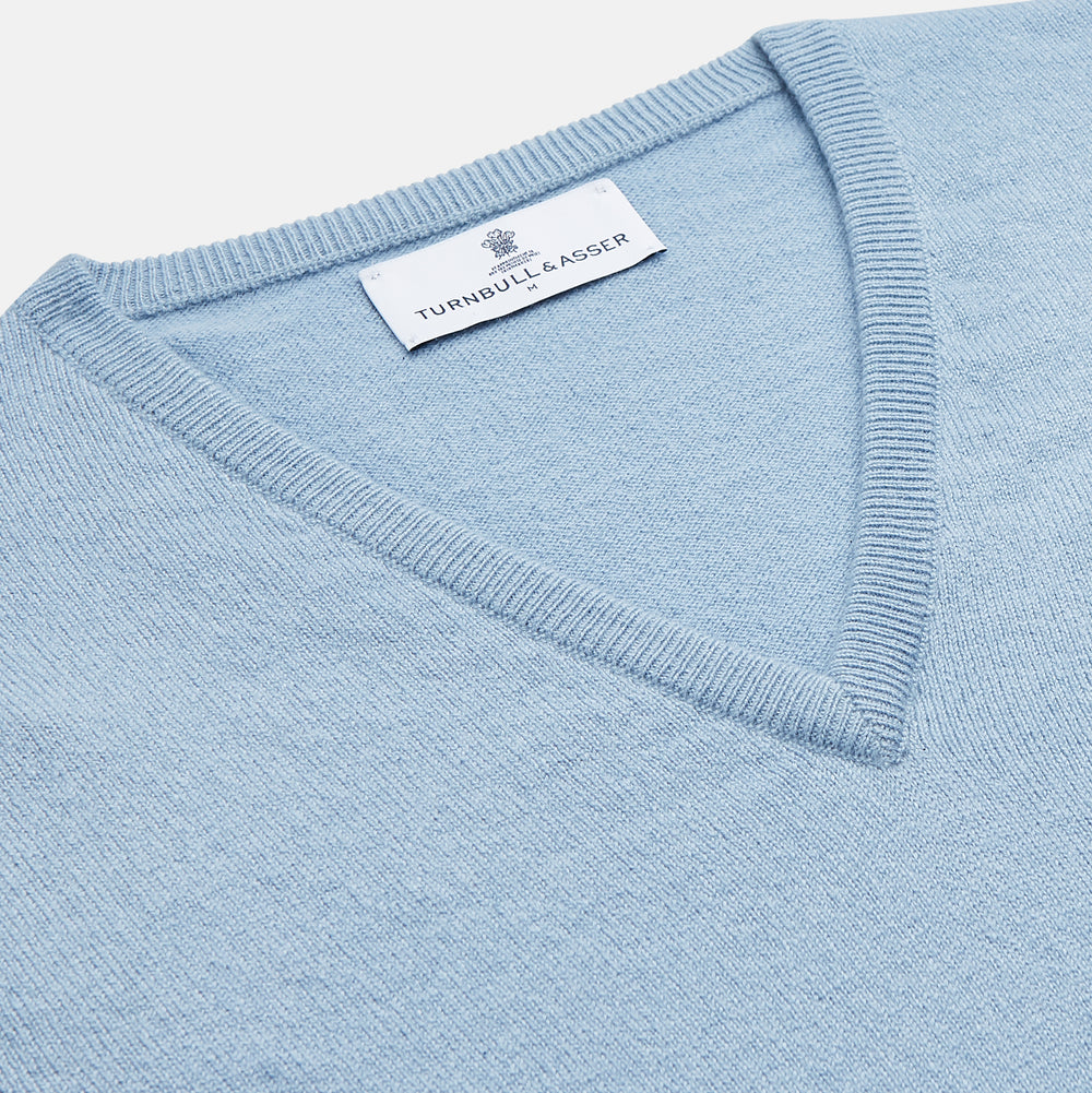 The Turnbull & Asser Pale Blue Cashmere Ifor Slipover is a sleeveless V-neck sweater vest with ribbed edges, shown laid flat on a white background—a classic menswear staple.