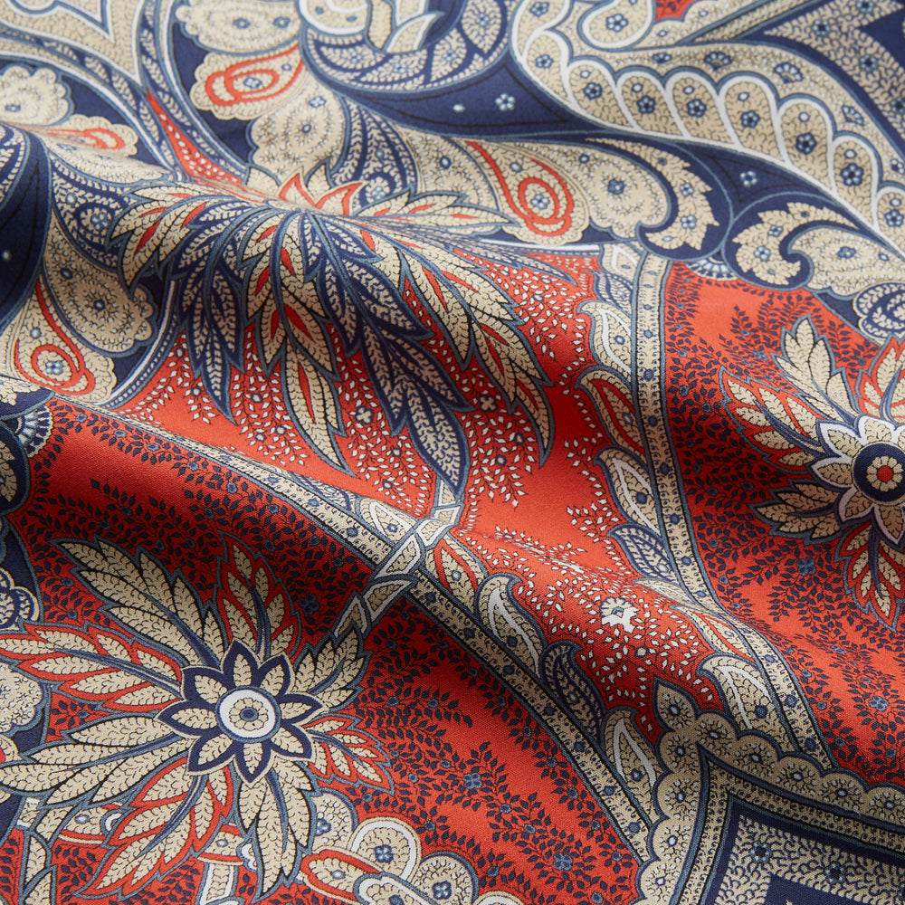 The Turnbull & Asser Red Baroque Silk-Blend Hyde Pyjama Set features a long-sleeve button-up shirt and matching pants in an intricate red, blue, and beige floral-geometric print, displayed flat against a white background.
