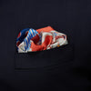 View 2 of product The Pink and Red Lily Silk Pocket Square by Turnbull & Asser features a vibrant, hand-drawn floral design with large lilies and abstract shapes in pink, white, blue, and yellow on pale blue vertical stripes.