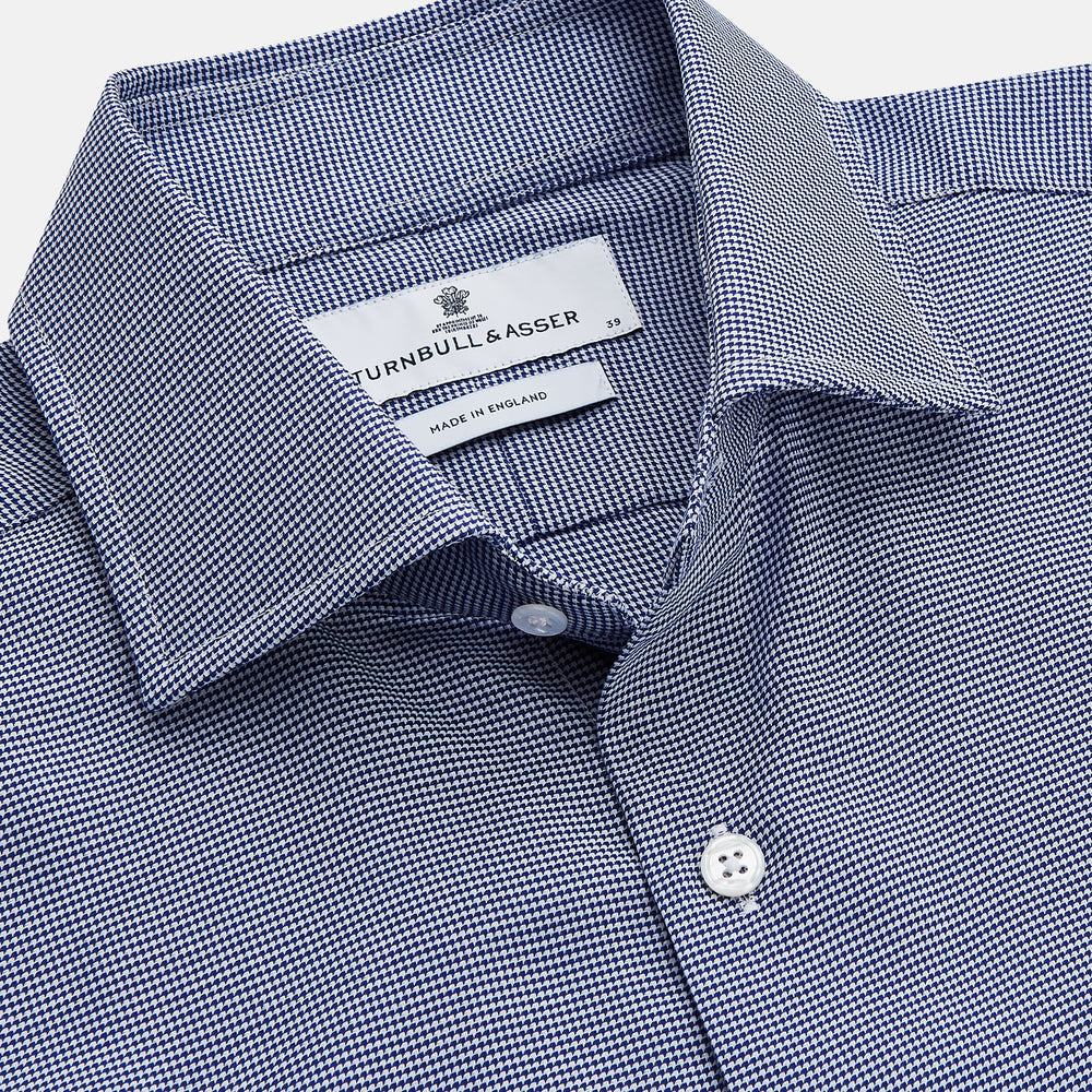 The Turnbull & Asser Navy Pattern Cotton Voile Tailored Fit Shelton Shirt is laid flat, showcasing its classic collar and white front and cuff buttons.