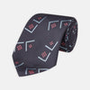 View 1 of product A Turnbull & Asser Navy Graphic Deco Silk Tie, featuring light blue chevrons and red squares on a dark navy background, shown rolled up against a plain white backdrop.