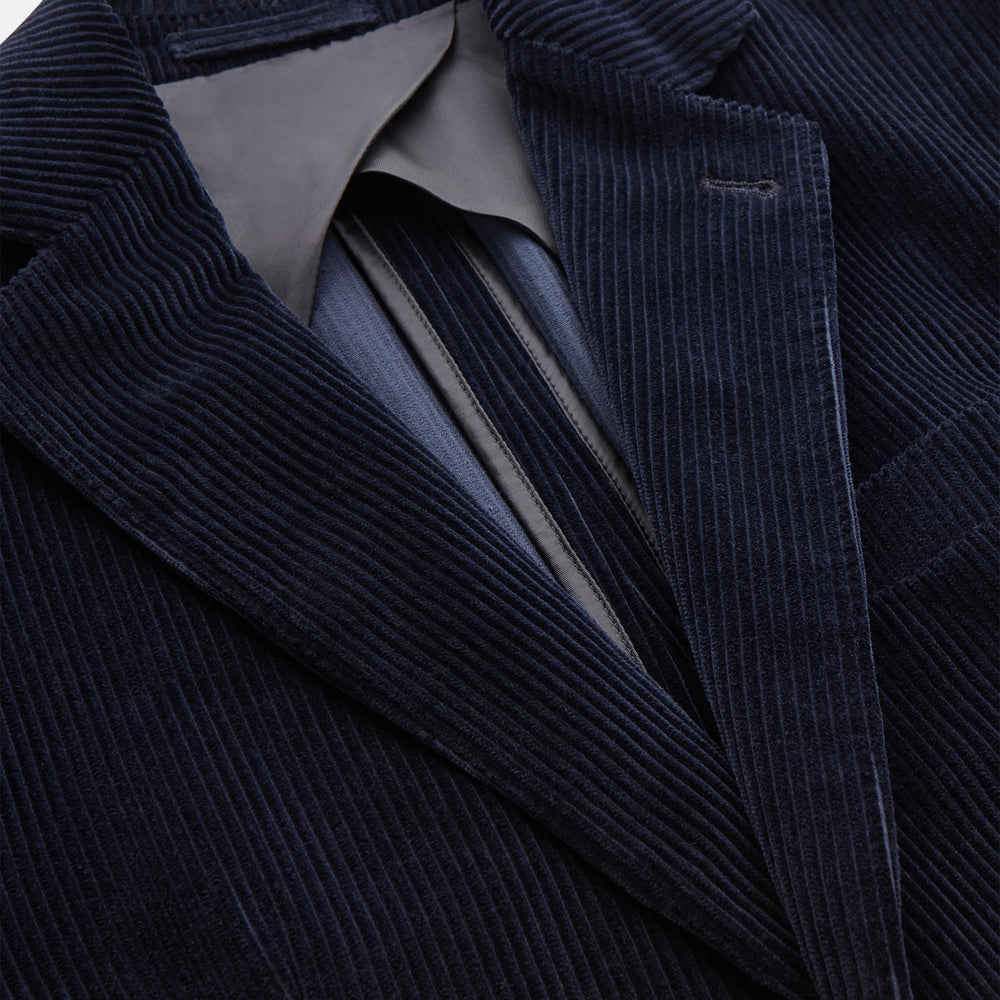 The Turnbull & Asser Navy Cord Bern Blazer, featuring notched lapels, a single button closure, two front pockets, and buttoned cuffs, exemplifies refined Italian tailoring and is shown laid flat on a white background.