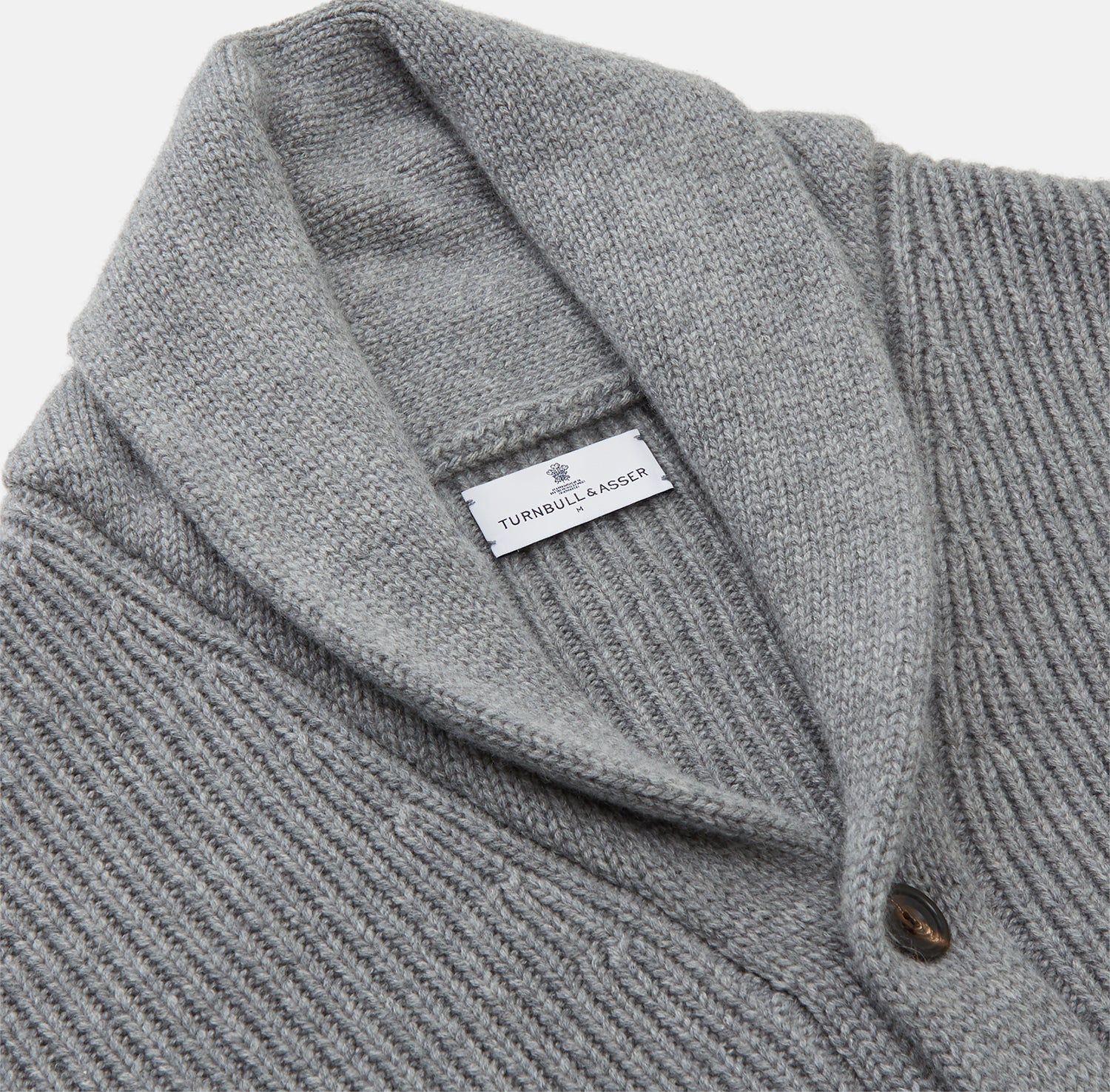 View 2 of product The Turnbull & Asser Grey Ribbed Cashmere Ainsley Cardigan is a luxury 3-ply cashmere knit with a shawl collar, button-up front, and two front pockets, shown laid flat on a white background.