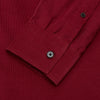 View 3 of product The Turnbull & Asser Burgundy Corduroy Officer Weekend Fit Shirt features a Dorset collar, long sleeves, one-button cuffs, and two chest pockets with buttoned flaps, shown laid flat on a white background.