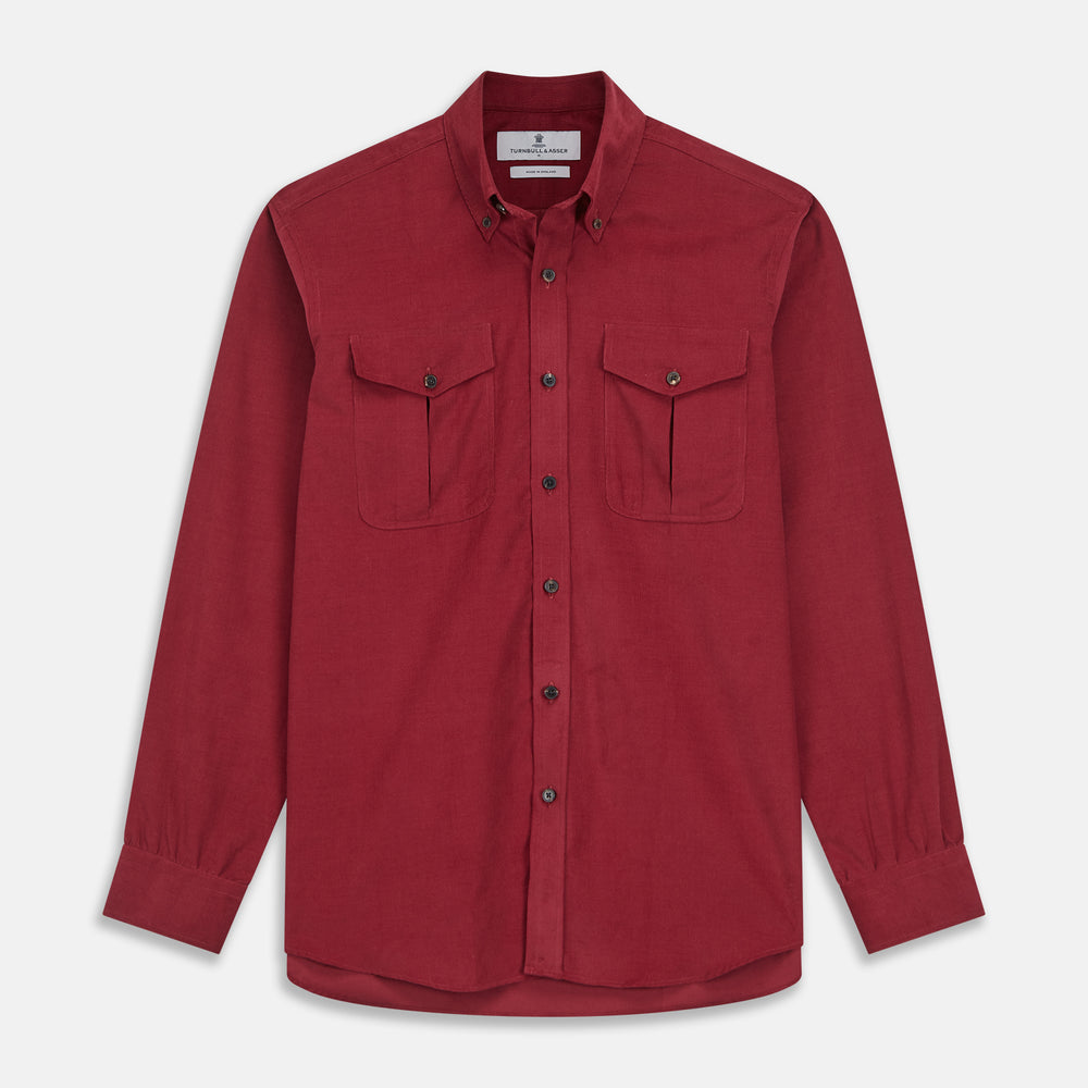 The Turnbull & Asser Burgundy Corduroy Officer Weekend Fit Shirt features a Dorset collar, long sleeves, one-button cuffs, and two chest pockets with buttoned flaps, shown laid flat on a white background.