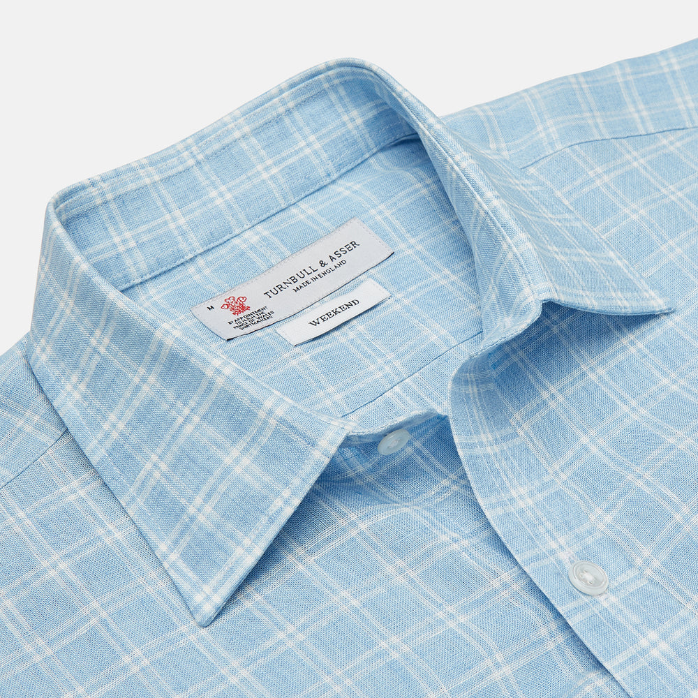 The Turnbull & Asser Weekend Fit Blue Plaid Linen Shirt features a white check pattern, Derby collar, long sleeves with 1-button cuffs, single chest pocket, and button-up front, shown against a white background.