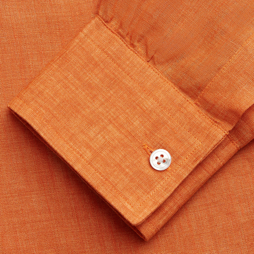 The Turnbull & Asser Orange Weekend Fit Linen Nevis Shirt features a Derby collar, long sleeves with 1-button cuffs, white buttons, and a chest pocket, shown flat against a white background.