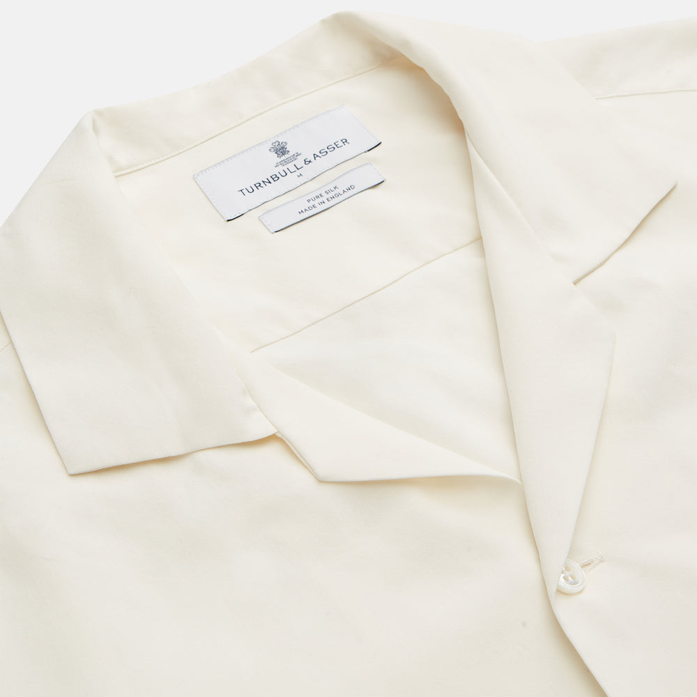 The Turnbull & Asser Cream Holiday Fit Silk Phillips Shirt features a revere collar, short sleeves, and three front pockets, shown flat on a white background.