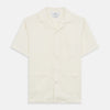 View 1 of product The Turnbull & Asser Cream Holiday Fit Silk Phillips Shirt features a revere collar, short sleeves, and three front pockets, shown flat on a white background.