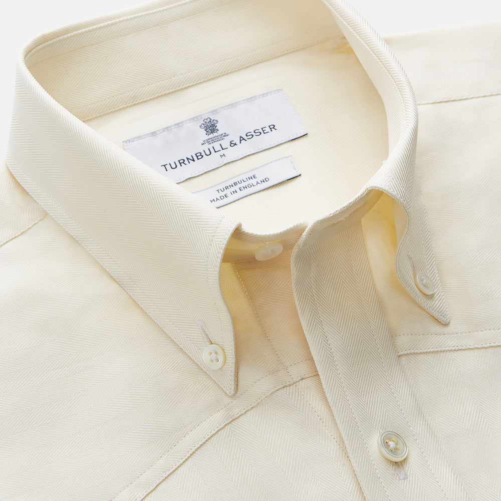 The Turnbull & Asser Cream Weekend Fit Larkin Shirt features a Dorset collar, 3-button cuffs, and two button-flap chest pockets in soft herringbone cotton, displayed flat on a white background.