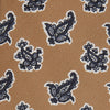 View 2 of product The Turnbull & Asser Toffee Paisley Floral Cotton Silk Blend Tie features a rolled-up design with dark blue and white paisley motifs on a tan background.