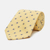 View 1 of product The Turnbull & Asser Yellow Fine Square Slub Silk Tie features a soft yellow jacquard with a subtle texture, decorated with a repeating blue and white diamond pattern, shown rolled up on a plain white background.