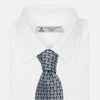 View 4 of product The Chambray Blue Graphic Floral Silk Jacquard Tie by Turnbull & Asser features a modern floral pattern in silk, shown rolled up against a plain white background.