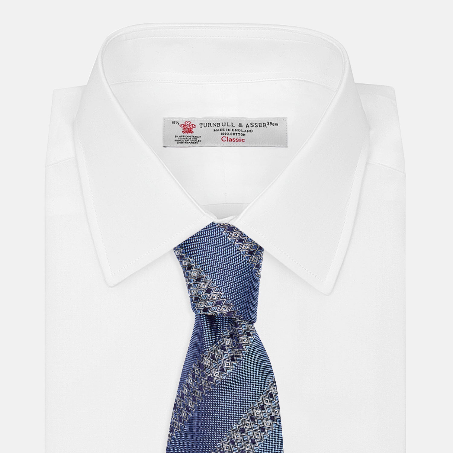 View 4 of product The Turnbull & Asser Dark Blue Baroque Stripe Silk Jacquard Tie, featuring elegant baroque stripes, is displayed rolled up on a white background.