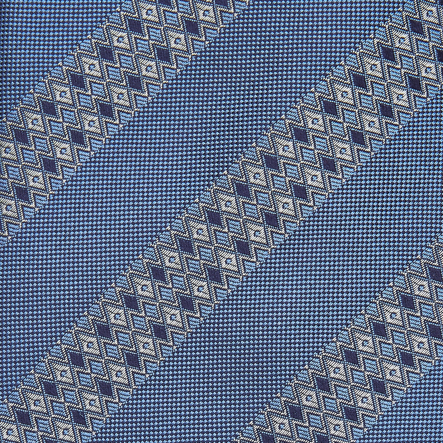 View 2 of product The Turnbull & Asser Dark Blue Baroque Stripe Silk Jacquard Tie, featuring elegant baroque stripes, is displayed rolled up on a white background.
