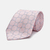 View 1 of product The Turnbull & Asser Baby Pink and Blue Circle Jacquard Silk Tie features a subtle geometric pattern, elegantly rolled against a plain white background.