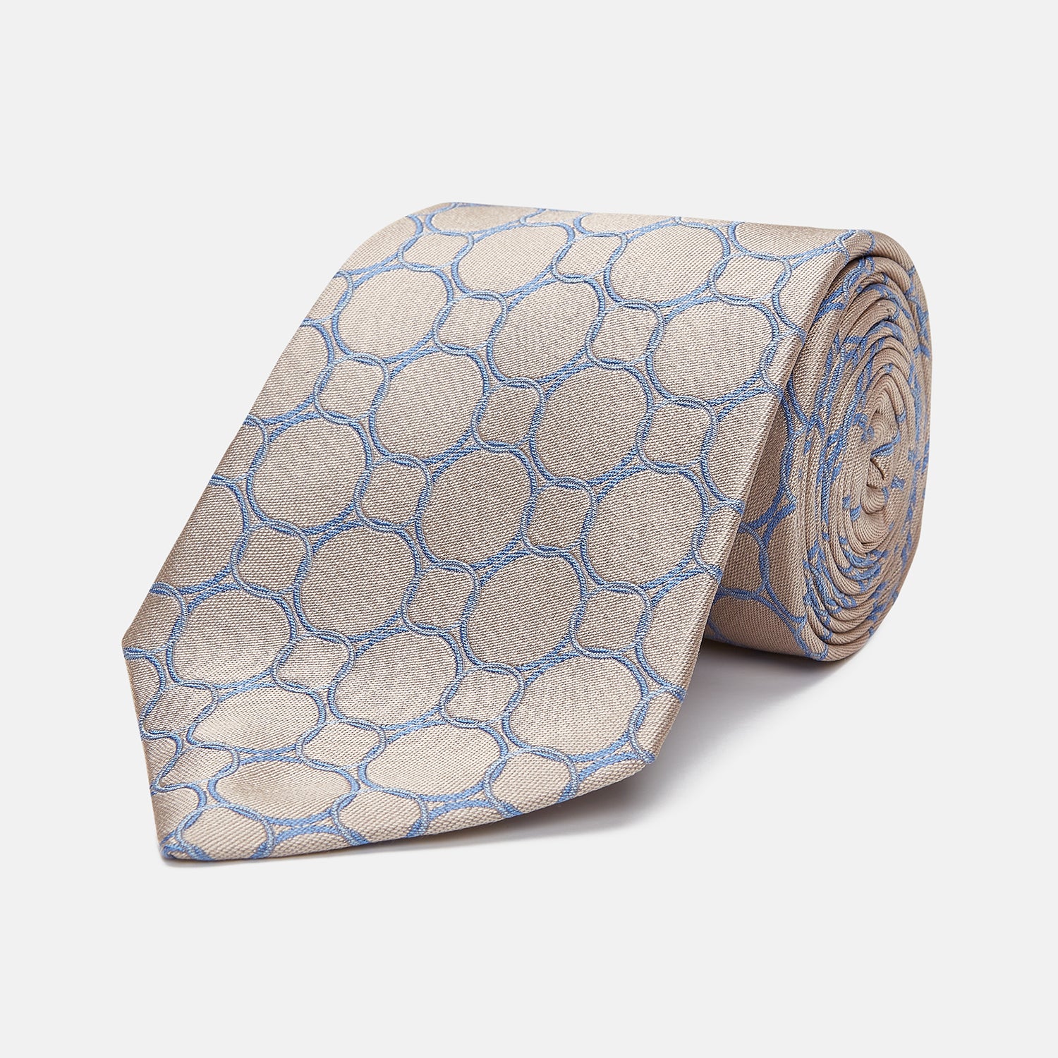 View 1 of product The Turnbull & Asser Toffee and Powder Blue Circle Jacquard Silk Tie, featuring an interlocking circular pattern, is rolled up and displayed on a plain white background.