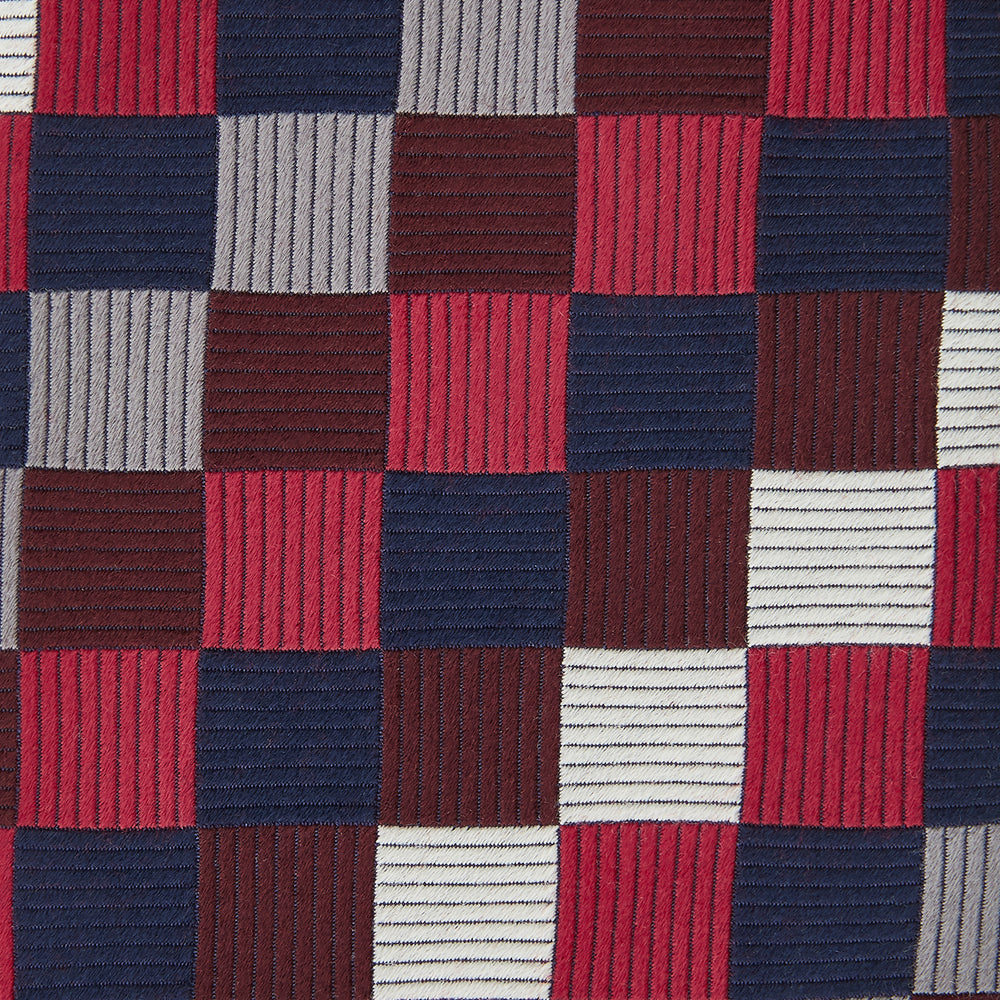 The Burgundy Checkerboard Silk Jacquard Tie by Turnbull & Asser features a bold autumnal pattern in red, navy blue, brown, gray, burgundy, and white squares, shown rolled on a plain white background.