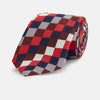 View 1 of product The Burgundy Checkerboard Silk Jacquard Tie by Turnbull & Asser features a bold autumnal pattern in red, navy blue, brown, gray, burgundy, and white squares, shown rolled on a plain white background.