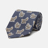 View 1 of product The Turnbull & Asser Navy Paisley Floral Cotton Silk Blend Tie features beige and light blue paisley motifs on navy, with one end rolled.