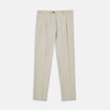 View 1 of product Turnbull & Asser's Stone Cotton Twill Pleated Trousers feature a relaxed fit, front pleats, side pockets, belt loops, and button closure, shown laid flat on a white background.