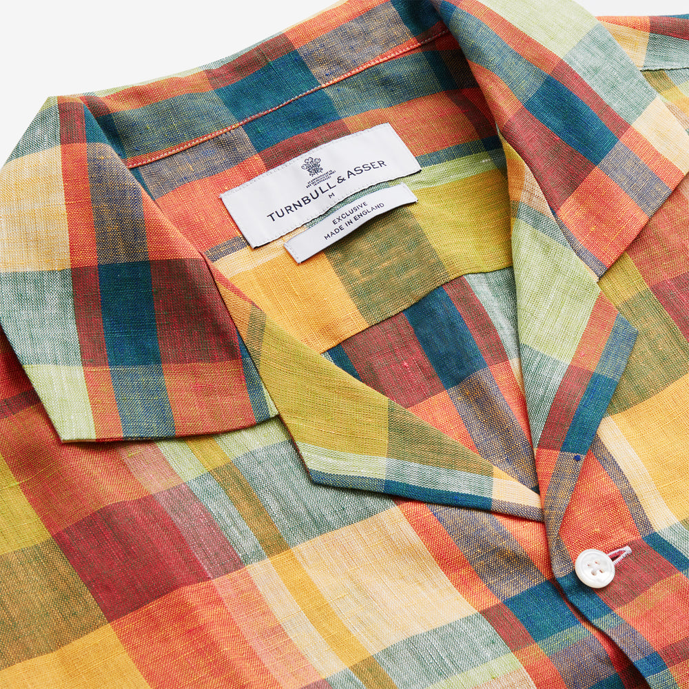 Turnbull & Asser's Orange Madras Check Holiday Fit Long Sleeve Linen Shirt features a bold plaid in orange, yellow, green, and blue with a revere collar and 1-button cuff—ideal for effortless holiday style. Laid flat on white background.