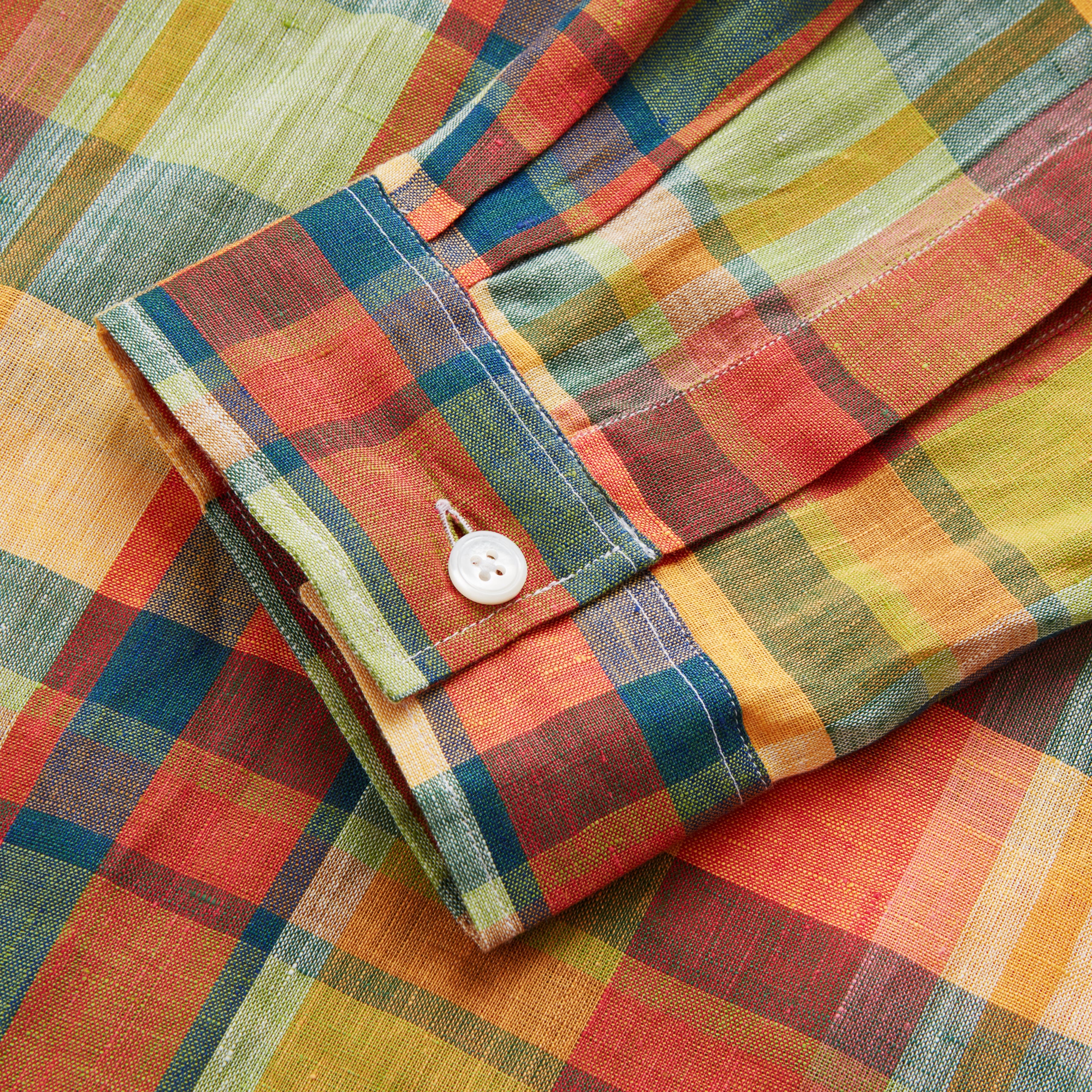 View 5 of product Turnbull & Asser's Orange Madras Check Holiday Fit Long Sleeve Linen Shirt features a bold plaid in orange, yellow, green, and blue with a revere collar and 1-button cuff—ideal for effortless holiday style. Laid flat on white background.