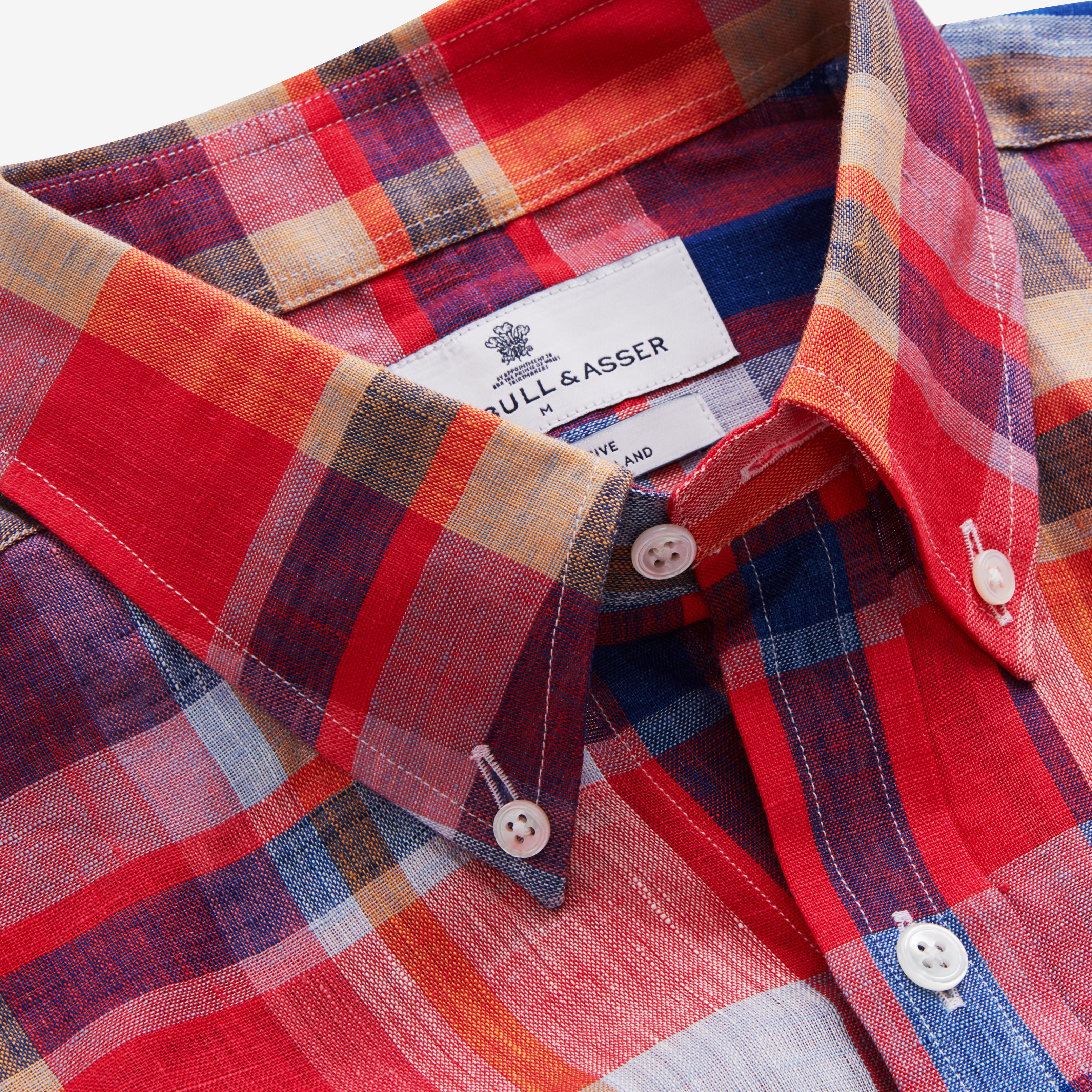View 4 of product The Turnbull & Asser Red Madras Check Weekend Fit Short Sleeve Linen Shirt features a Dorset collar, white buttons, and a red, blue, white, and beige plaid pattern. Shown on a plain white background.