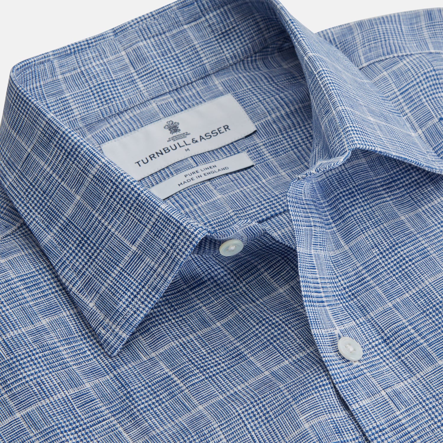 View 3 of product The Indigo Linen Glen Check Weekend Fit Shirt with Derby Collar by Turnbull & Asser is a light blue, long-sleeve checked linen shirt, featuring a subtle white plaid pattern and shown against a plain white background.