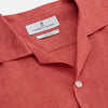 View 3 of product The Turnbull & Asser Crimson Delave Linen Holiday Fit Shirt features a solid brick-red hue, short sleeves, single chest pocket, and revere collar—perfect resort wear—shown laid flat on white.