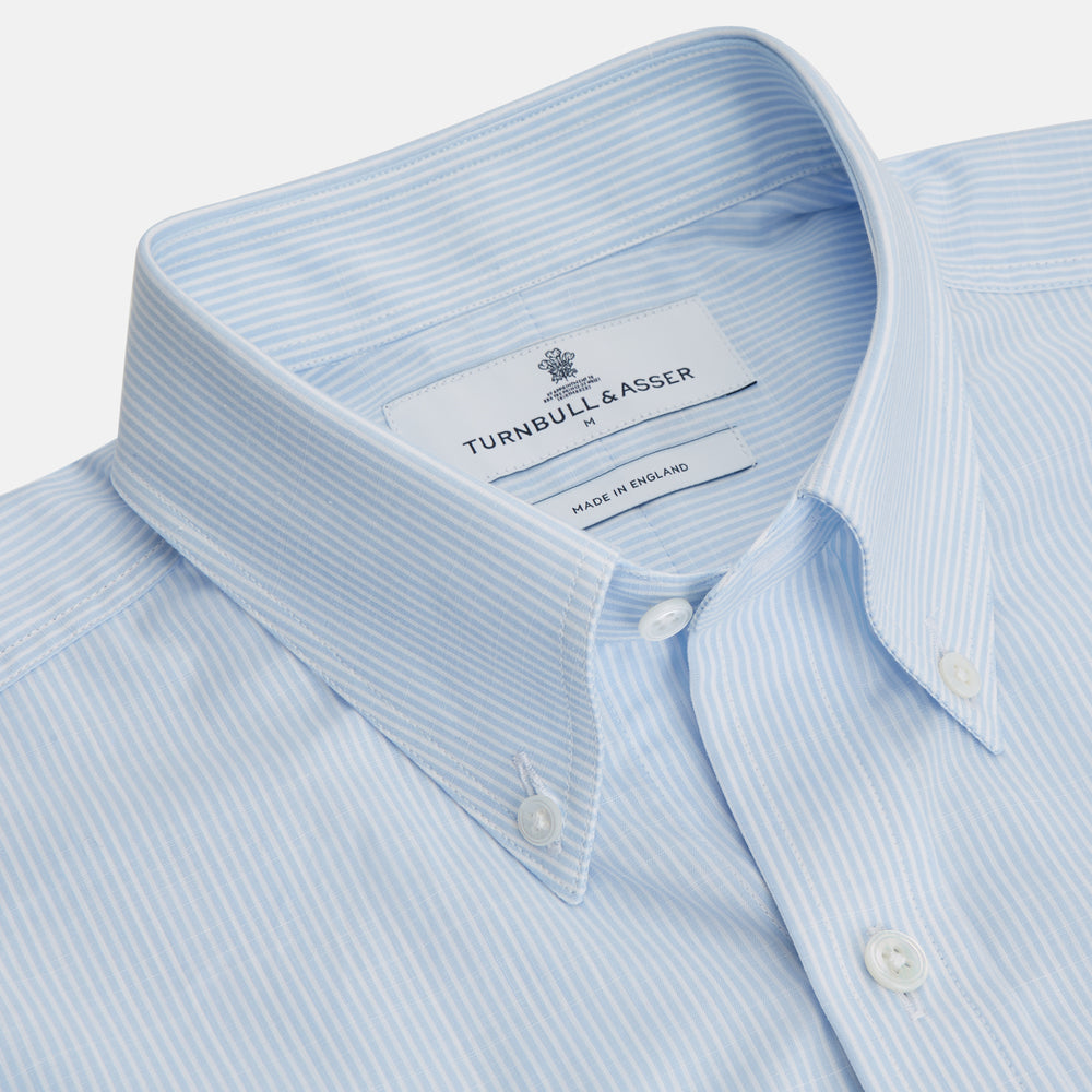 The Turnbull & Asser Sky Blue Chambray Stripe Weekend Fit Shirt features a Dorset collar, long sleeves, and two button-flap chest pockets, offering a relaxed look. Displayed on a plain white background.