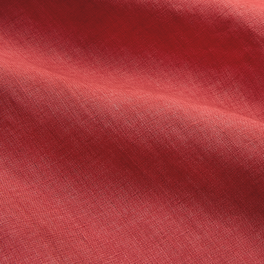 The Turnbull & Asser Crimson Delave Linen Holiday Fit Shirt features a solid brick-red hue, short sleeves, single chest pocket, and revere collar—perfect resort wear—shown laid flat on white.