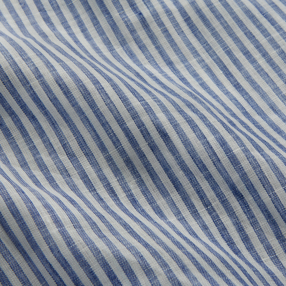 The Turnbull & Asser Sky Blue Linen Stripe Weekend Fit Shirt features blue and white vertical stripes, a Derby collar, and buttoned cuffs—ideal for pairing with classic cotton suits or other Weekend Fit shirts.