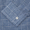 View 4 of product The Indigo Linen Glen Check Weekend Fit Shirt with Derby Collar by Turnbull & Asser is a light blue, long-sleeve checked linen shirt, featuring a subtle white plaid pattern and shown against a plain white background.