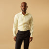 View 1 of product A man stands against a beige background, wearing the Turnbull & Asser Cream Tailored Fit Shelton Shirt with a Kent collar and black pants. He faces forward with a neutral expression, his arms relaxed by his sides.