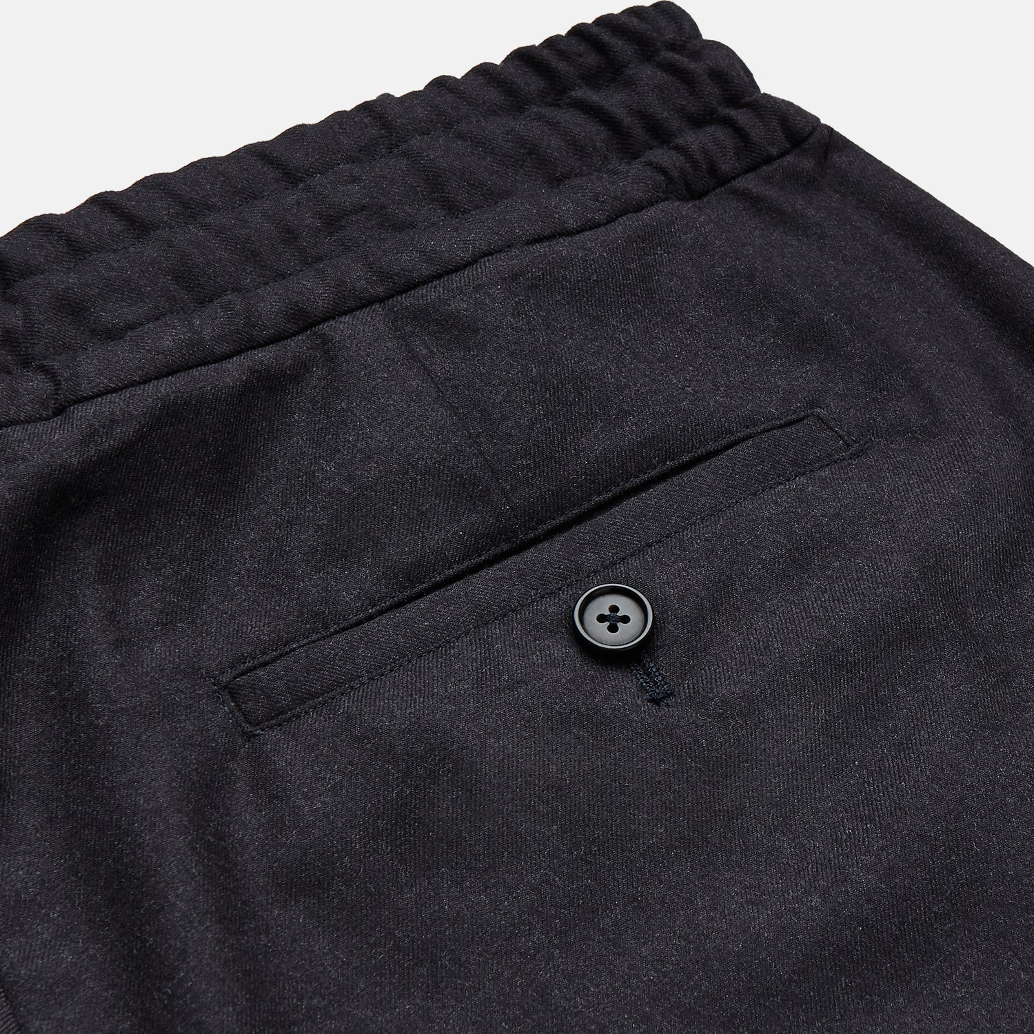View 3 of product Turnbull & Asser Charcoal Tailored Drawstring Trousers in wool flannel, featuring an elastic waistband, straight legs, and side pockets, shown laid flat on a white background.