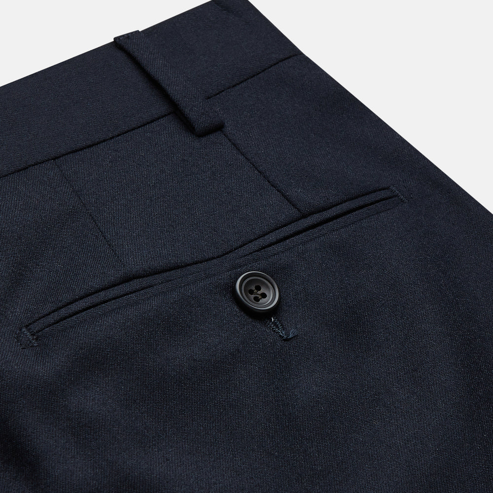 The Navy Wool Pleated Jasper Trouser by Turnbull & Asser features lightweight wool, a button and zipper closure, front pockets, and straight legs, shown neatly pressed against a plain white background.