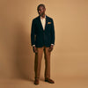 View 8 of product A man stands against a tan background wearing a Turnbull & Asser Orange Multi Stripe Regular Fit Shirt with T&A Collar and 3 Button Cuffs, paired with tan dress pants, brown belt, and brown shoes. He faces forward with a neutral expression.