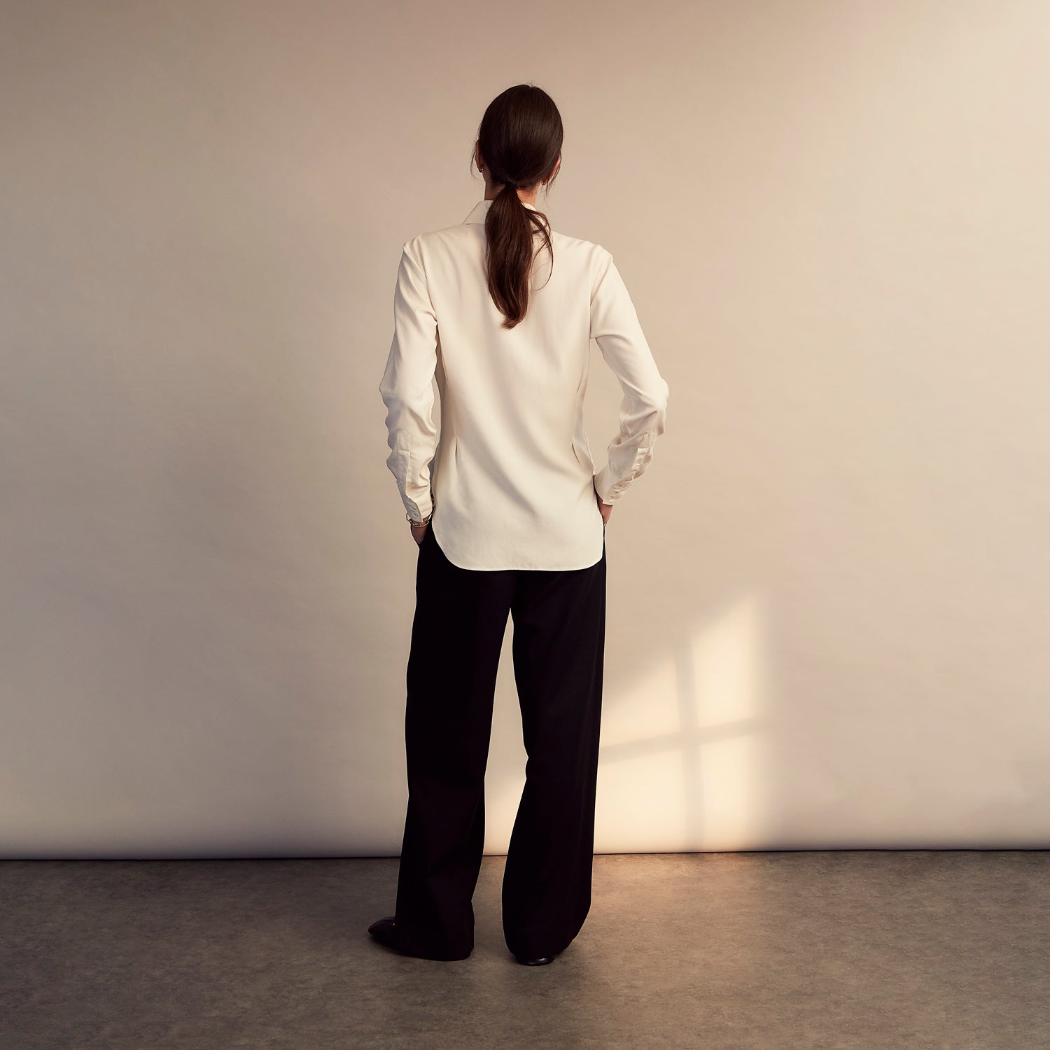 View 10 of product The Turnbull & Asser Turnbull and The Deck Cream Silk Romantic Shirt features long sleeves, a pointed collar, and elegant front ruffles, shown against a plain light gray background.