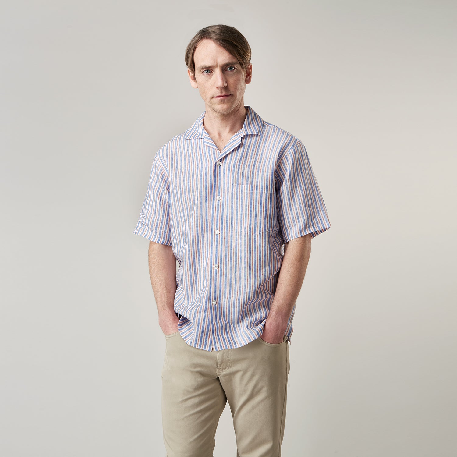 View 5 of product The Turnbull & Asser Blue and Red Linen Stripe Holiday Fit Shirt features a revere collar, relaxed fit, and short sleeves—perfect resort wear with vertical blue, white, and light red stripes.