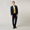 View 4 of product A man stands against a plain background, wearing a Turnbull & Asser Green Fine Stripe Regular Fit Shirt with a T&A collar, paired with a yellow tie, dark trousers, and black shoes. He looks slightly left with his hands at his sides.