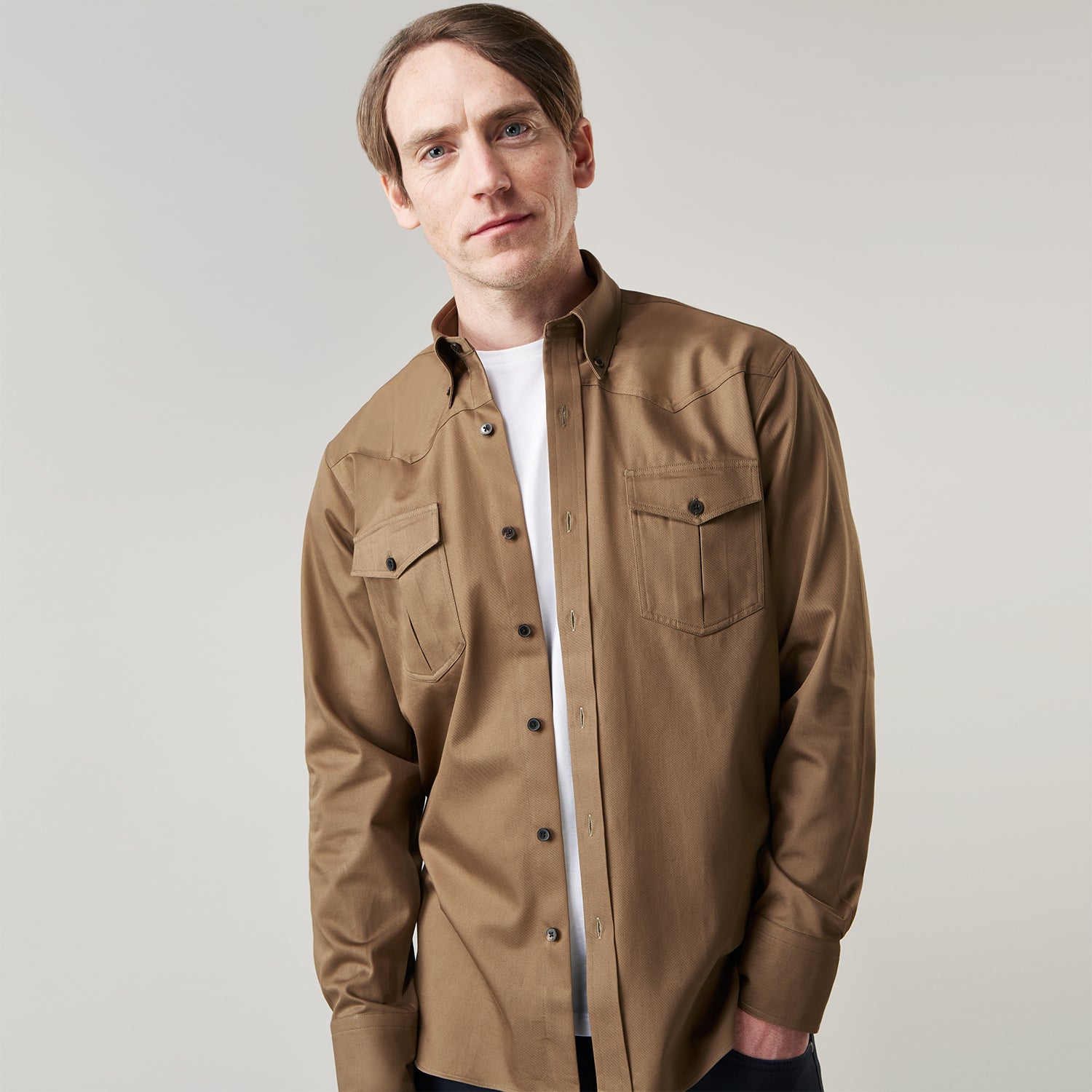 View 6 of product The Turnbull & Asser Khaki Cotton Weekend Fit Western Shirt features a Dorset collar, long sleeves, two button-flap chest pockets, and buttoned cuffs—an essential smart-casual piece shown against a white background.