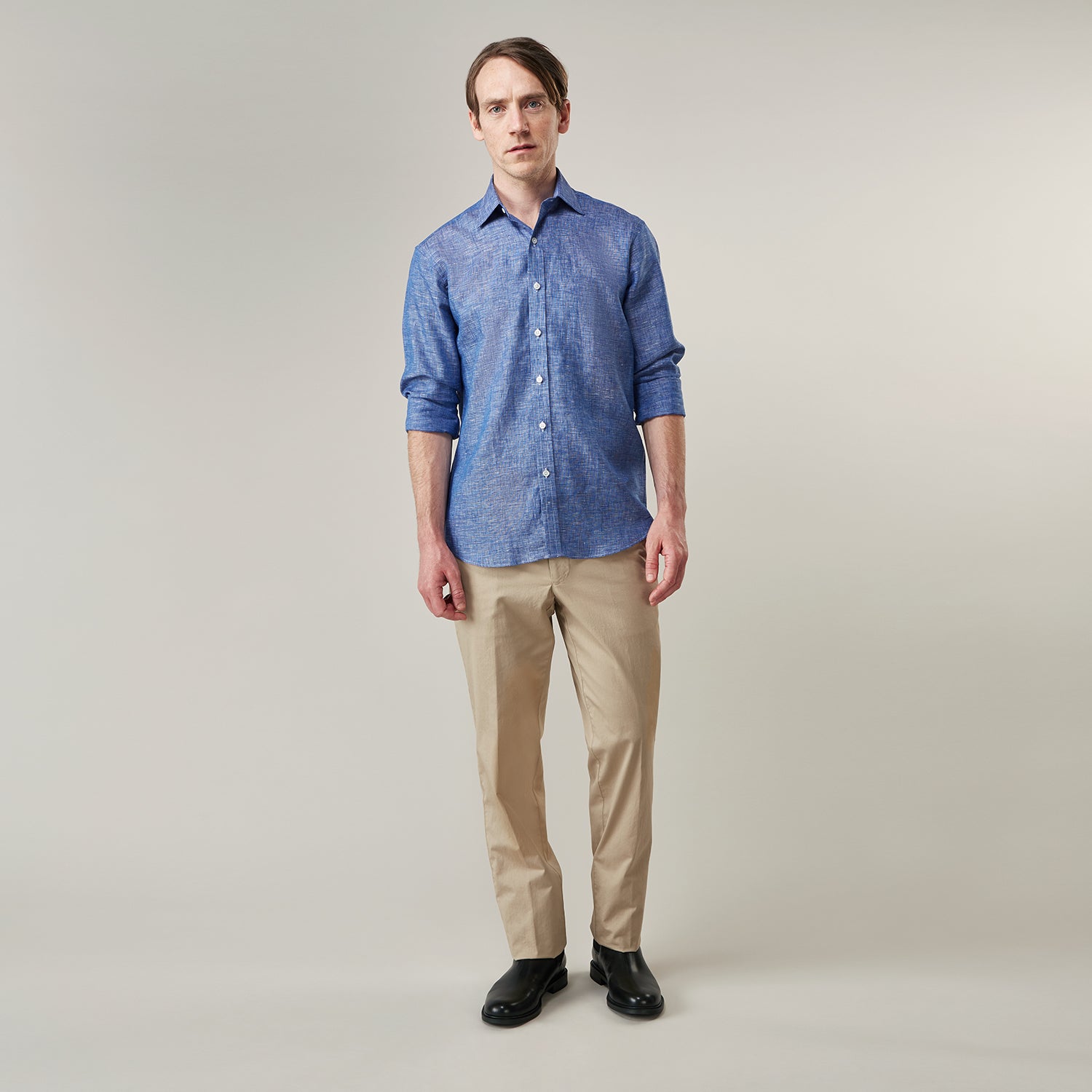 View 2 of product The Indigo Linen Weekend Fit Shirt with Derby Collar by Turnbull & Asser, shown flat on a white background, features long sleeves, white buttons, and buttoned cuffs—ideal for pairing with a classic suit or for casual wear.